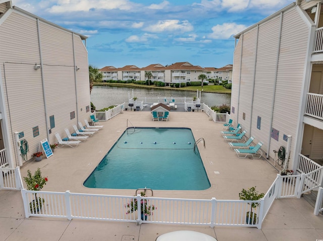 view of swimming pool with a water view and a patio area