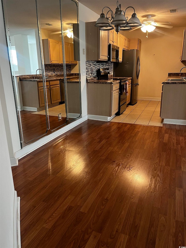 kitchen featuring ceiling fan, sink, backsplash, appliances with stainless steel finishes, and light hardwood / wood-style floors