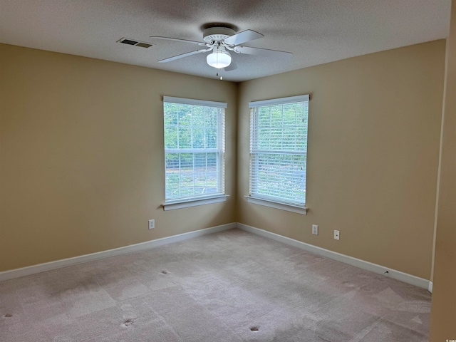 carpeted spare room with ceiling fan and a textured ceiling