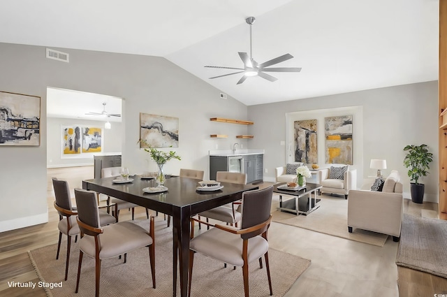 dining space featuring ceiling fan, light hardwood / wood-style floors, and lofted ceiling