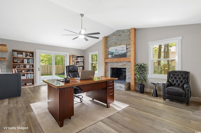 office area featuring ceiling fan, a fireplace, light hardwood / wood-style floors, and lofted ceiling