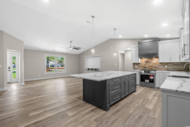 kitchen featuring a kitchen island, light stone counters, lofted ceiling, gray cabinets, and stainless steel range with electric cooktop