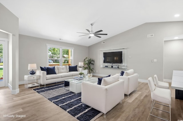 living room featuring ceiling fan, vaulted ceiling, and light wood-type flooring