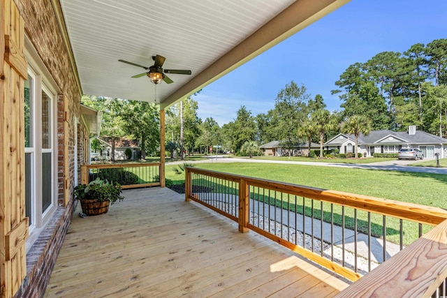 deck featuring covered porch, a yard, and ceiling fan