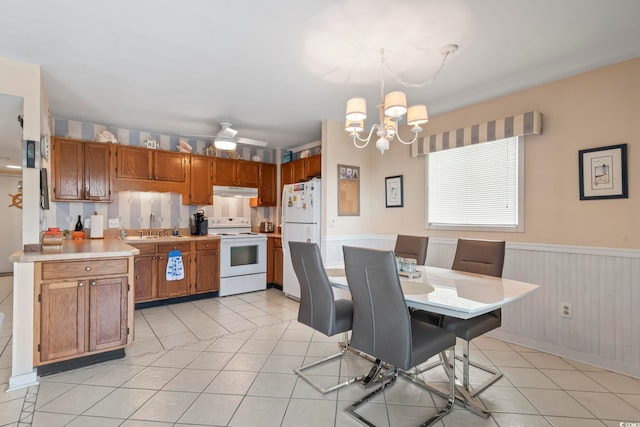 5905 S Kings Hwy Unit 219-B, Myrtle Beach, SC 29575 - kitchen with white appliances, light tile patterned floors, a chandelier, light countertops, and brown cabinets
