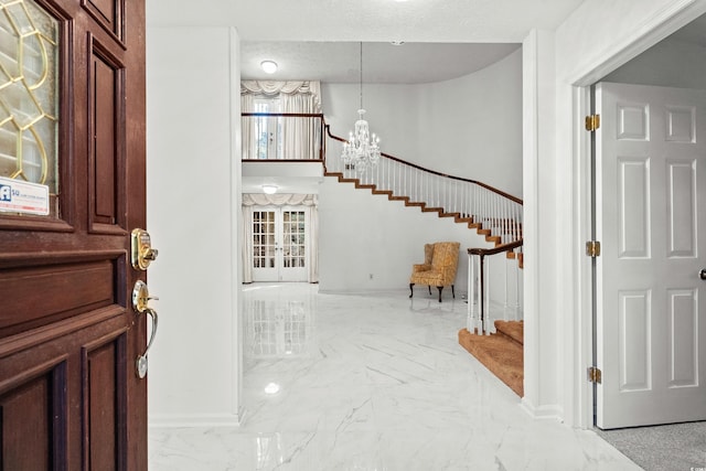 foyer featuring an inviting chandelier and a textured ceiling