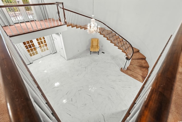 stairs with a chandelier and french doors