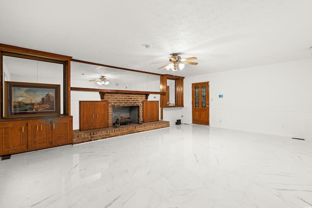 unfurnished living room featuring a textured ceiling, ceiling fan, and a brick fireplace