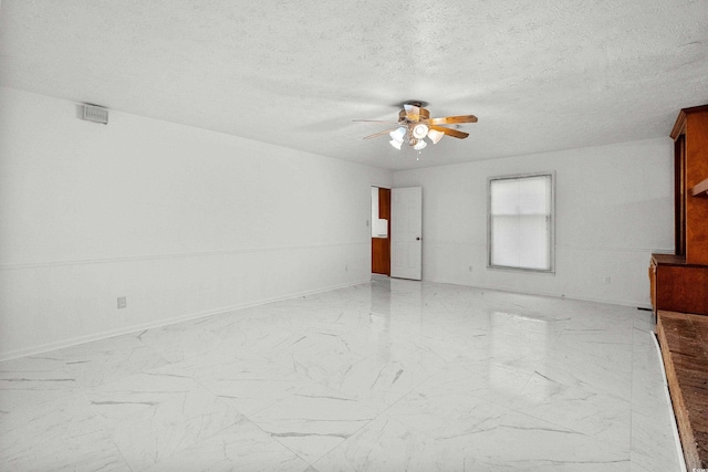 empty room with a textured ceiling and ceiling fan