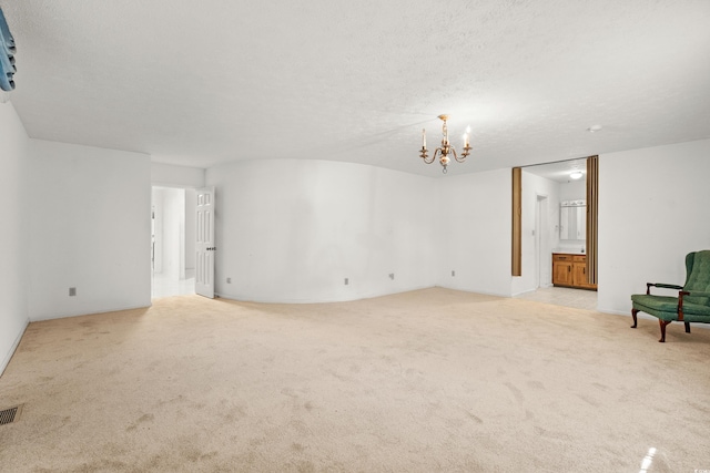 interior space featuring light carpet, a chandelier, and a textured ceiling