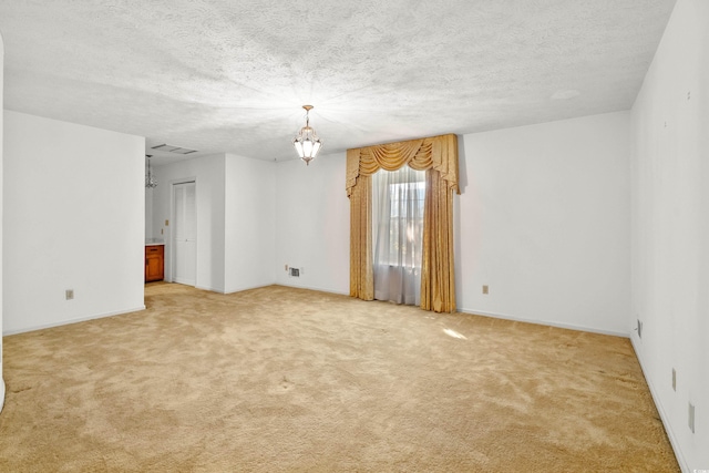 carpeted empty room with a textured ceiling