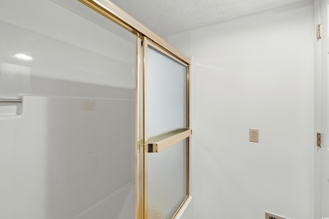 bathroom featuring a textured ceiling and walk in shower