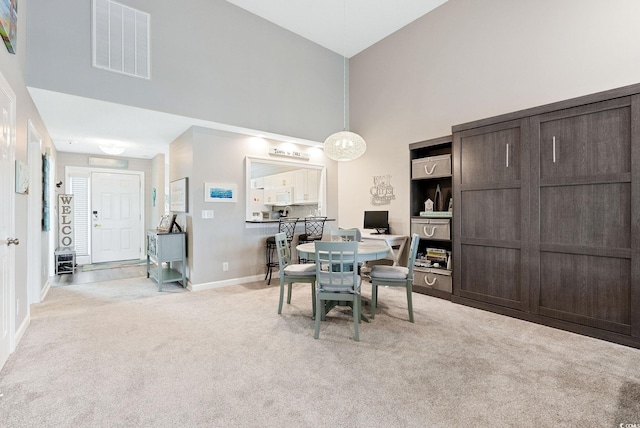 dining room with high vaulted ceiling and light colored carpet