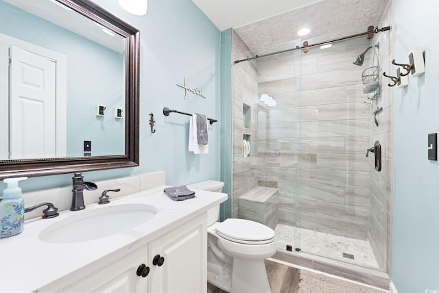 bathroom with walk in shower, vanity, and toilet