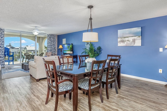 dining room featuring a textured ceiling, hardwood / wood-style floors, and ceiling fan