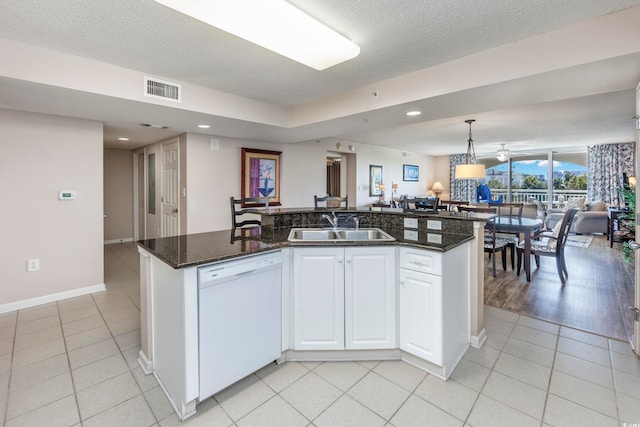 kitchen featuring a kitchen island with sink, dishwasher, pendant lighting, and sink