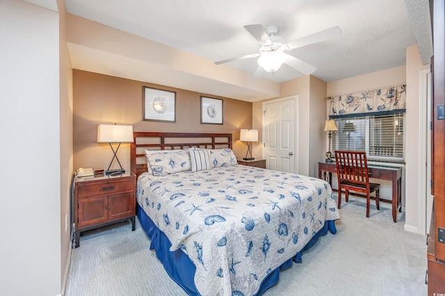 carpeted bedroom featuring a textured ceiling and ceiling fan