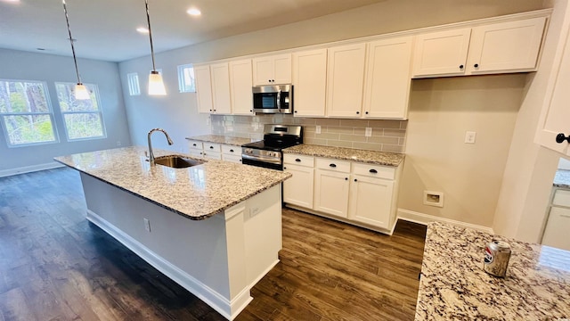 kitchen with sink, white cabinets, hanging light fixtures, and appliances with stainless steel finishes