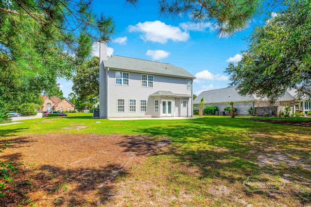 back of property with a lawn, central air condition unit, and a patio area