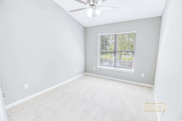 spare room with vaulted ceiling, ceiling fan, and light colored carpet