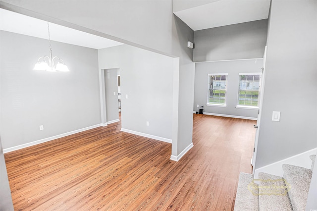 interior space featuring a notable chandelier, a towering ceiling, and hardwood / wood-style flooring