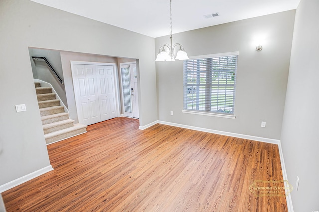 unfurnished dining area featuring a notable chandelier and hardwood / wood-style floors