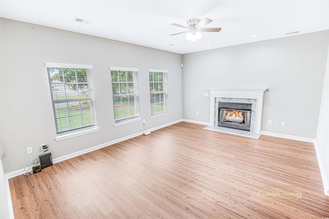 unfurnished living room featuring light hardwood / wood-style floors, a fireplace, and ceiling fan