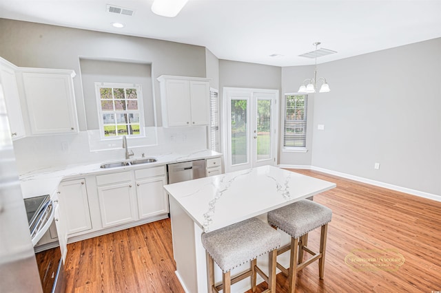 kitchen featuring a kitchen island, sink, light hardwood / wood-style flooring, and white cabinets