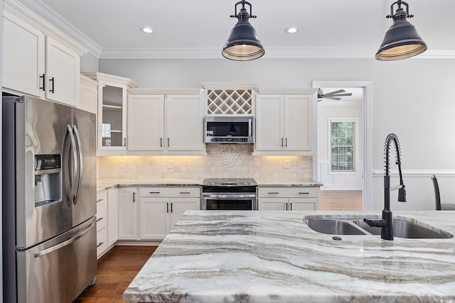 kitchen with light stone counters, sink, appliances with stainless steel finishes, decorative light fixtures, and ceiling fan