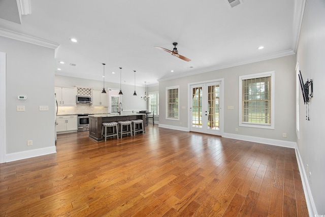 living room featuring crown molding, dark hardwood / wood-style flooring, ceiling fan, and french doors