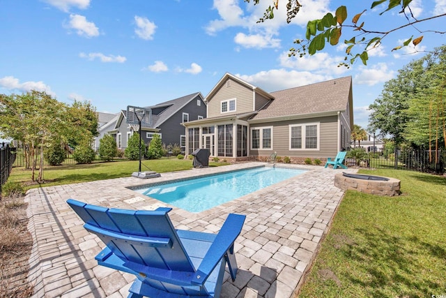 view of pool featuring a patio, a yard, and a fire pit