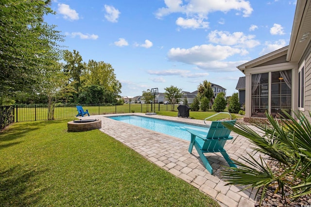 view of swimming pool with a lawn, a sunroom, a patio area, and a fire pit