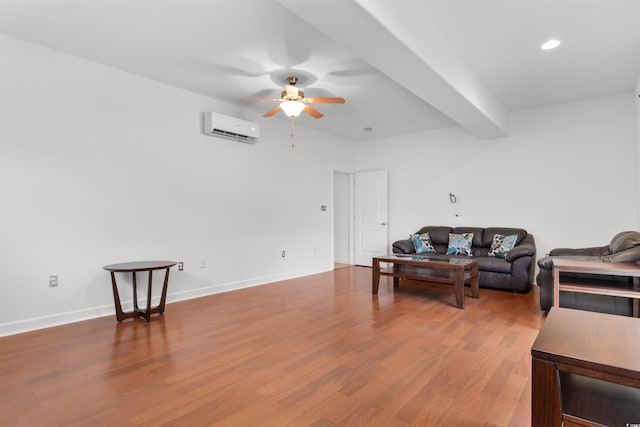 living area featuring beamed ceiling, baseboards, wood finished floors, a ceiling fan, and a wall unit AC