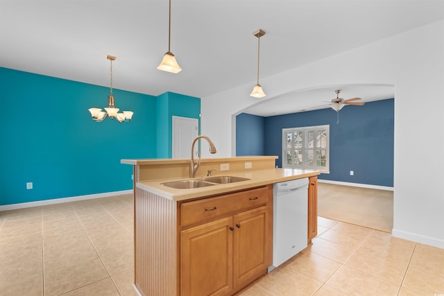 kitchen with ceiling fan with notable chandelier, white dishwasher, decorative light fixtures, a center island with sink, and sink