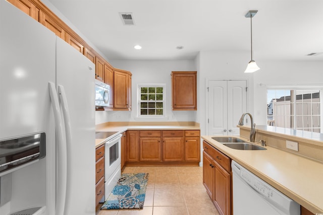 kitchen featuring white appliances, light tile patterned flooring, sink, and decorative light fixtures