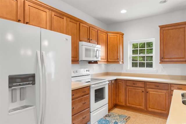 kitchen featuring light tile patterned flooring, light countertops, brown cabinets, white appliances, and recessed lighting