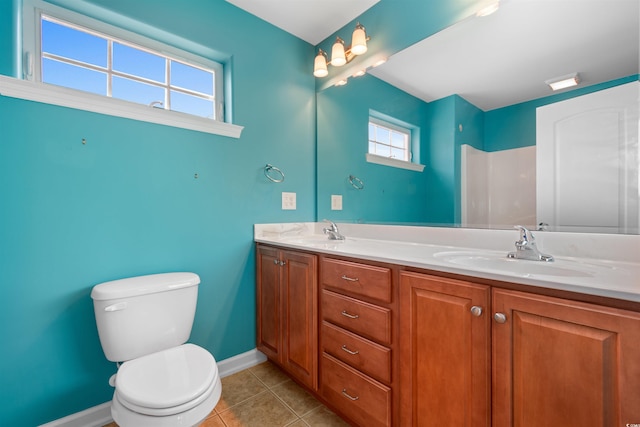 bathroom with tile patterned floors, toilet, baseboards, and a sink
