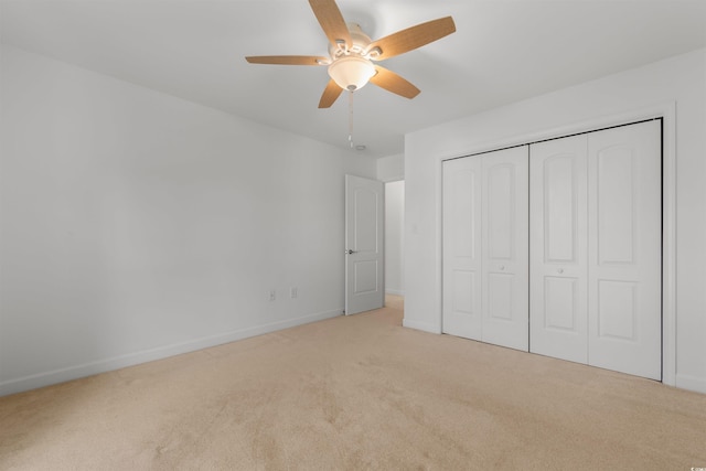 unfurnished bedroom with a closet, ceiling fan, and light colored carpet