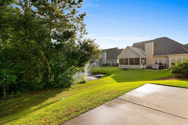 view of yard with a sunroom and a patio area