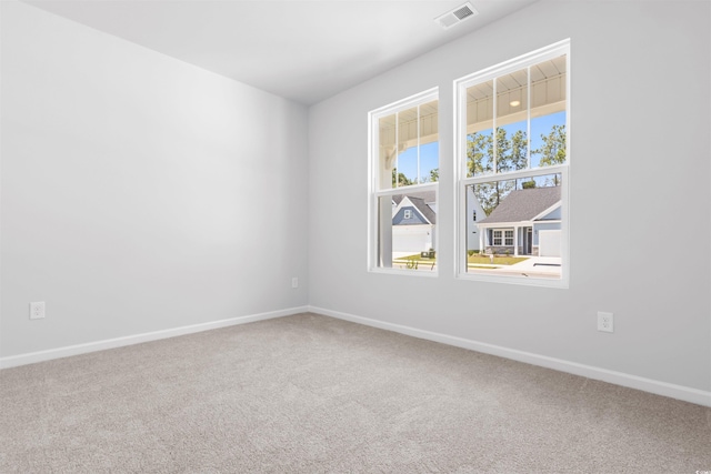 carpeted spare room with baseboards and visible vents