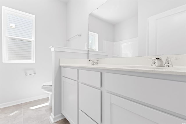 full bath featuring double vanity, baseboards, toilet, tile patterned floors, and a sink