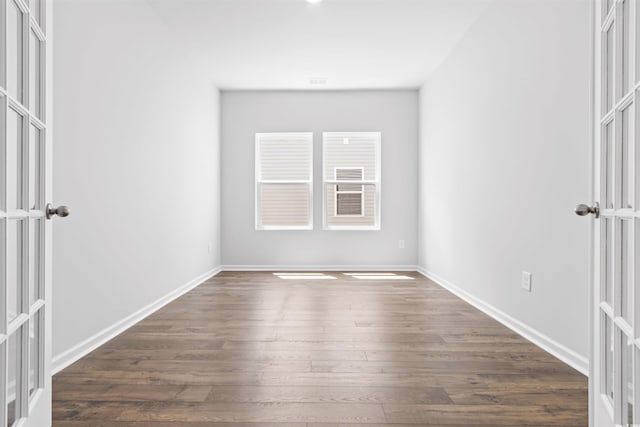 spare room with baseboards, dark wood-style flooring, and french doors