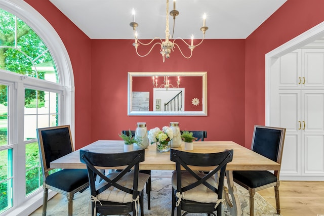 dining area featuring light wood-style flooring and an inviting chandelier