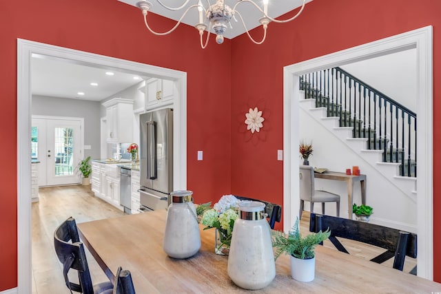 dining area featuring stairs, light wood finished floors, recessed lighting, and an inviting chandelier