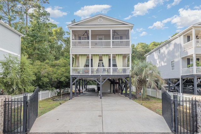 coastal home with a porch, a balcony, and a carport