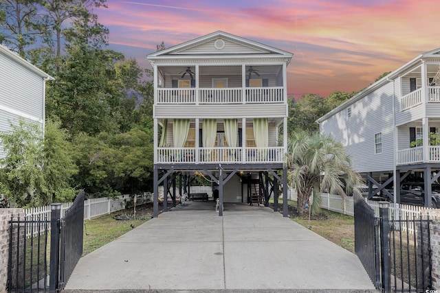 beach home with a balcony, covered porch, and a carport