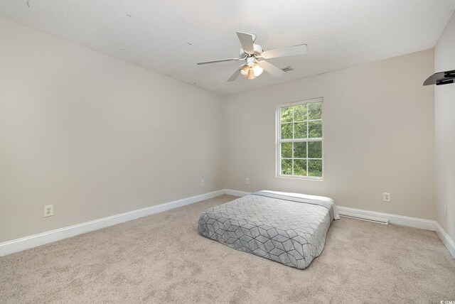 bedroom with ceiling fan, a textured ceiling, and light colored carpet