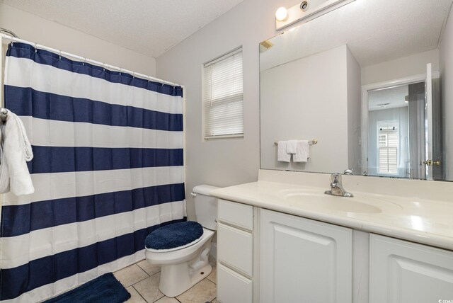 bathroom with vanity, a textured ceiling, toilet, and tile patterned floors