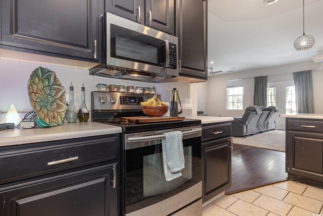 kitchen featuring appliances with stainless steel finishes, pendant lighting, and light hardwood / wood-style floors