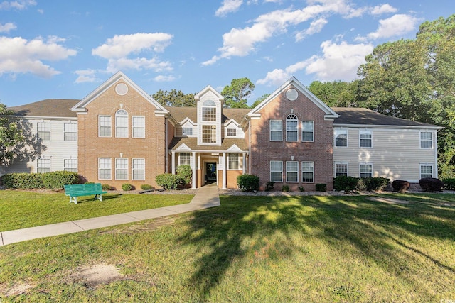 view of front facade featuring a front lawn and brick siding